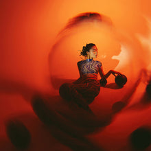 Load image into Gallery viewer, An editorial-style fashion portrait of a model, enhanced by the LLP V4 Black Halo Prism Filter. The filter introduces intriguing light fractures and a moody, atmospheric bokeh that complements the model’s pose and expression, creating a high-fashion visual narrative.
