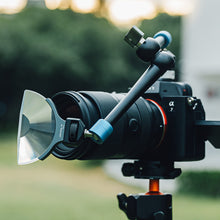 Load image into Gallery viewer, Close-up detail of the LLP V4 Half Halo Handheld Filter securely mounted to a DSLR camera via a flexible magic arm (articulating arm). This setup demonstrates the filter’s professional adaptability, allowing for precise positioning and stable use in various shooting scenarios.
